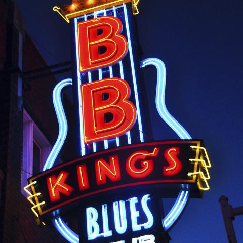 Neon sign for B B Kings Blues Club with crown, guitar outline, red “BB” letters, and “BLUES CLUB” text.